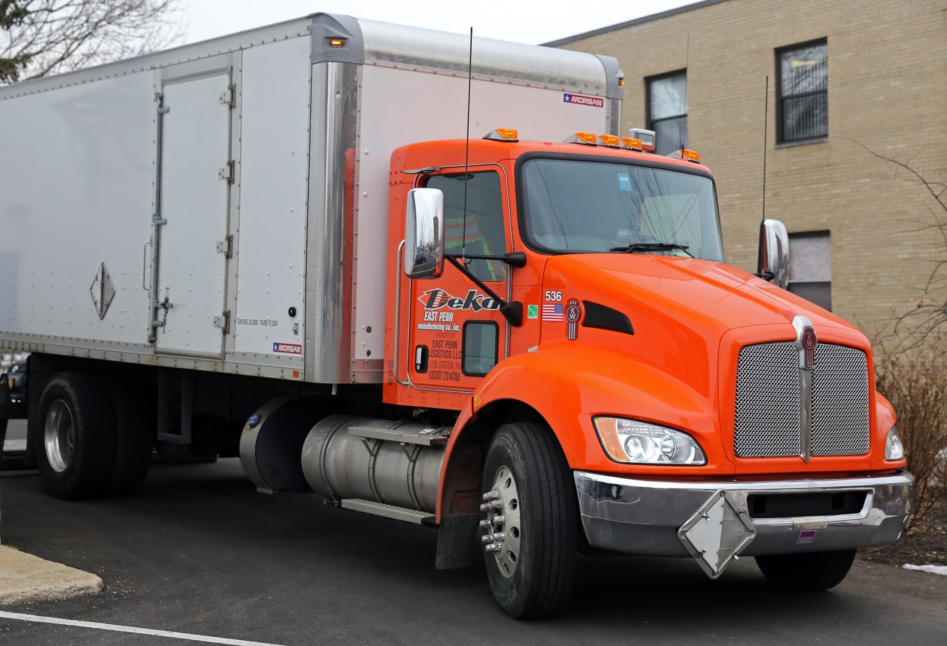 A Kenworth T270-series boxvan truck. Very orange.